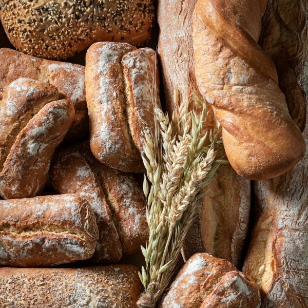 Brown baguettes and buns baked in bakery. Made of wheat.